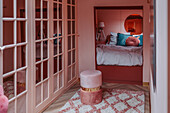 Retro bedroom with mirrored wardrobe and cosy sleeping alcove in shades of pink and blue