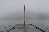 Wet jetty over foggy ocean, Kollafjorour, Faroe Islands\n