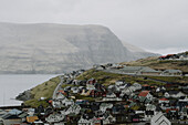 Häuser am Wasser in einem Dorf am Hang, Eidi, Eysturoy, Färöer Inseln