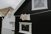 Wäscheklammern an der Wäscheleine vor den Häusern im Fischerdorf, Gjogv, Eysturoy, Färöer Inseln