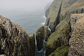 Blick auf majestätische grüne Klippen und Schornsteine über dem Meer, Dunnesdrangar, Vagar, Färöer Inseln