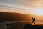 Silhouettierter Wanderer auf Berg mit Blick auf idyllischen Sonnenuntergang, Assynt, Sutherland, Schottland