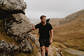 Mann wandert in schroffen Bergen, Assynt, Sutherland, Schottland