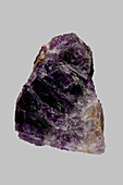 Close up textured purple Brazilian amethyst on gray background\n