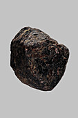 Close up black Indian almandine stone on gray background\n