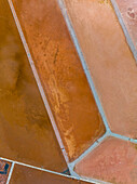 Luftaufnahme von braunen Salzteichen, die ein geometrisches Muster bilden, Mallorca, Spanien