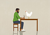 Man with fork and knife staring at chicken on dining table\n