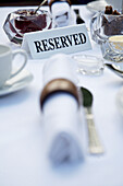 Close up of breakfast table with napkins and reserved sign\n