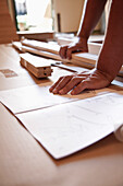 Close up of man's hands on flat pack furniture instructions\n