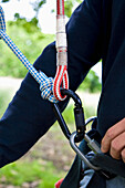 Close up of climber arm and climbing gear\n