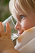 Nahaufnahme eines jungen blonden Jungen beim Wassertrinken