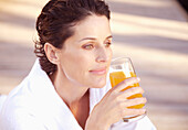 Woman smiling and drinking apple juice\n