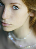 Close up of young beautiful woman with necklace\n