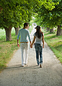 Young couple walking holding hands\n