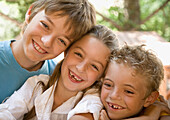 Portrait of three young children laughing\n