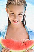 Smiling young girl holding water melon\n