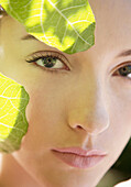 Portrait einer jungen Frau mit grünen Feigenblättern