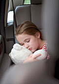 Portrait eines schlafenden Mädchens, das einen Teddybär kuschelt