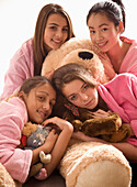 Mädchen im Teenageralter umarmen Teddybär