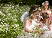 Young girls in fancy dress in a flower garden\n