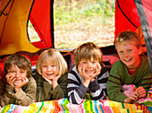 Portrait of children lying in a tent\n