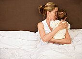 Porträt einer Frau im Bett mit ihrem neugeborenen Baby