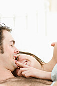 Close up of couple in bed laughing\n