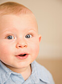 Close up of cute baby boy with mouth open\n