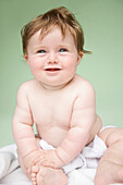 Portrait of a baby on green background\n