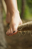 Close up of a woman feet walking on tightrope\n