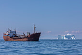 Freighter near iceberg from the nearby Ilulissat Icefjord floating near Ilulissat, Western Greenland, Polar Regions\n