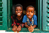 Young school kids looking out from a window, Ciudad de la Paz, Rio Muni, Equatorial Guinea, Africa\n