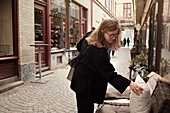 Woman shopping for cushions on outdoor display\n