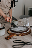 Frau schneidet frisch gebackenen Schokoladenkuchen an