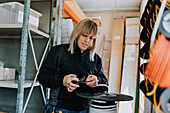 Female electrician cutting cable at work\n