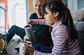 Father and daughter bonding over planting seedlings on balcony\n