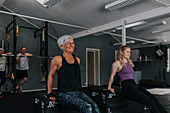 Lächelnde Frauen trainieren zusammen im Fitnessstudio