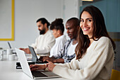 Smiling woman sitting during business meeting and looking at camera\n