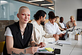 Woman sitting during business meeting and looking at camera\n