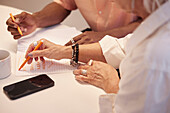 View of coworkers hands during business meeting\n