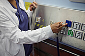Mid section of female doctor pressing lift button\n
