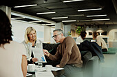 Group of business people having meeting in lobby\n