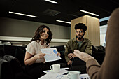 Group of business people analyzing charts during meeting in lobby\n