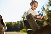 Little girl standing at playground and looking away\n