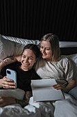 High angle view of homosexual couple relaxing in bed together\n