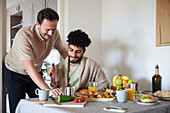 Glückliches schwules Paar frühstückt zu Hause
