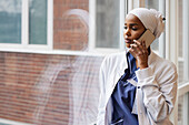 Young female doctor talking on phone at work\n