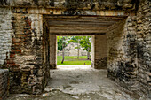 The doorway in Structure A2 frames Pyramid B1 in the Mayan ruins in the Cahal Pech Archeological Reserve, Belize.\n