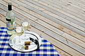 White wine bottle and glasses on table outdoors\n