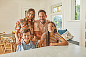 Portrait einer lächelnden Familie mit zwei Kindern (8-9, 12-13) in der Küche